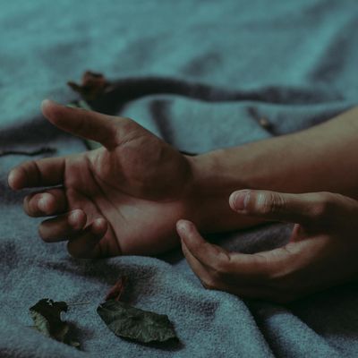 A person's hands resting gently on their knees in a meditative posture.